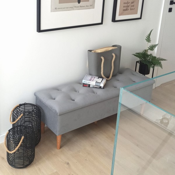 Szara tapicerowana ławka z miękkim siedziskiem.