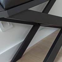 Stelaż czarny z kształtem idealnie wyciętym na listwę przypodłogową.