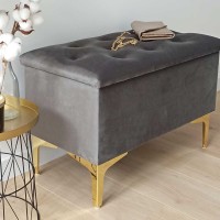 Ciemnoszara pufa ze złotymi nogami.