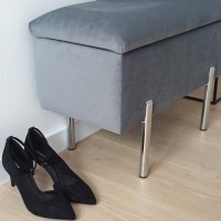 Detal metalowych nóg w skrzyni tapicerowanej do przedpokoju.